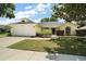 Charming single-story home with an attached two-car garage, lush landscaping, and a well-manicured lawn at 3677 Park Green Ct, Tavares, FL 32778