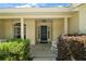 A welcoming front porch with decorative plants and a white rocking chair, creating a cozy entrance to the home at 3677 Park Green Ct, Tavares, FL 32778