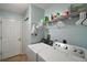 Well-organized laundry room with washer, dryer, storage shelf, and pale blue walls at 3677 Park Green Ct, Tavares, FL 32778
