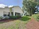 Beautifully landscaped backyard featuring a covered lanai, lush greenery, and mature trees at 3718 Westerham Dr, Clermont, FL 34711