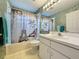 Bathroom with shower and bathtub, vanity, mirror, and a unique shower curtain at 3718 Westerham Dr, Clermont, FL 34711
