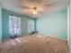 Well-lit bedroom with carpet, light-aqua walls, and a ceiling fan and light fixture at 3718 Westerham Dr, Clermont, FL 34711
