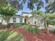 Attractive single-story home featuring mature landscaping, a two-car garage, and decorative ground cover at 3718 Westerham Dr, Clermont, FL 34711