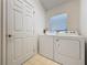 This is a laundry room with a door, window, washer and dryer at 3718 Westerham Dr, Clermont, FL 34711