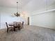 Living room and dining area with beige carpet and chandelier over the table at 3718 Westerham Dr, Clermont, FL 34711