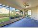 A screened-in lanai offers relaxation with serene views of the landscaped backyard and blue flooring at 3718 Westerham Dr, Clermont, FL 34711