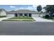 Charming duplex with manicured lawn and gray roof at 435 Woodview Dr, Tavares, FL 32778