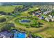 An aerial view features the golf course, pond, pool, and homes in this community at 4716 Heritage Trl, Leesburg, FL 34748