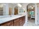 Modern bathroom featuring granite countertops, dual sinks, and access to the main bedroom at 4716 Heritage Trl, Leesburg, FL 34748