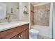 Bathroom with a granite countertop, wood cabinet, and shower with a tile surround at 4716 Heritage Trl, Leesburg, FL 34748