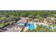 Aerial shot of the community pool area featuring a pool, lounge chairs, lush landscaping, and shade at 4716 Heritage Trl, Leesburg, FL 34748