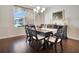 The dining room features a large window, a chandelier, and a long table with seating for eight at 4716 Heritage Trl, Leesburg, FL 34748