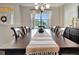 The dining room features a large window, a chandelier, and a long table with seating for eight at 4716 Heritage Trl, Leesburg, FL 34748