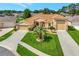 This well-maintained tan house has an inviting front yard with green grass and a convenient three-car garage at 4716 Heritage Trl, Leesburg, FL 34748