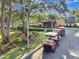 A row of golf carts sit parked near the clubhouse in a well-manicured landscape at 4716 Heritage Trl, Leesburg, FL 34748
