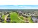 Aerial view of the community golf course featuring rolling hills, mature trees, and manicured greens at 4716 Heritage Trl, Leesburg, FL 34748