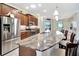 Modern kitchen boasts stainless steel appliances, granite counters, breakfast bar seating, and warm wood cabinetry at 4716 Heritage Trl, Leesburg, FL 34748