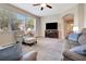 Inviting living room featuring neutral tones, cozy seating arrangements, and natural light from large windows at 4716 Heritage Trl, Leesburg, FL 34748