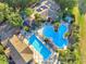 Aerial view of a pool with a long lap lane and a larger free-form pool and plenty of lounge chairs and lush landscaping at 4716 Heritage Trl, Leesburg, FL 34748