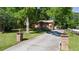 Charming brick home with a lush green lawn and long driveway, surrounded by mature trees, creating a serene setting at 5581 Sw 197Th Ter, Dunnellon, FL 34431