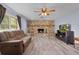 Living room featuring a stone fireplace and updated floors, bathed in natural light from a large window at 5581 Sw 197Th Ter, Dunnellon, FL 34431