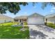 Inviting home with a well-kept lawn, concrete driveway, and attached two-car garage at 612 Lisbon Ln, The Villages, FL 32159