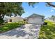Pleasant single-Gathering home featuring a long concrete driveway and a two-car garage at 612 Lisbon Ln, The Villages, FL 32159