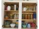 Kitchen cabinet showcasing organized glassware, dishware and dining essentials at 612 Lisbon Ln, The Villages, FL 32159