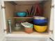 Kitchen cabinet featuring neatly organized bowls, strainers, and various cooking items at 612 Lisbon Ln, The Villages, FL 32159