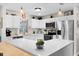 Bright kitchen features white cabinets, stainless steel appliances, quartz counters, and pendant lighting at 612 Lisbon Ln, The Villages, FL 32159