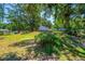 View of the backyard behind the house, showing landscaping and lush trees at 640 Sailfish Rd, Winter Springs, FL 32708