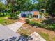Charming single-story home featuring a unique architecture, lush landscaping, and a welcoming brick driveway at 640 Sailfish Rd, Winter Springs, FL 32708