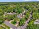 This aerial view highlights the property, with mature trees and a red brick driveway at 647 E 3Rd Ave, Mount Dora, FL 32757