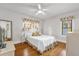 Bright bedroom with hardwood floors, white ceiling fan, and floral curtains at 647 E 3Rd Ave, Mount Dora, FL 32757