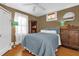 Bedroom with cozy bedding, hardwood floors, and built in shelving at 647 E 3Rd Ave, Mount Dora, FL 32757