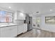 Well-lit kitchen with stainless steel refrigerator, white cabinets, and access to the screened patio at 647 E 3Rd Ave, Mount Dora, FL 32757