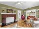 Cozy living room featuring a brick fireplace, wood floors, and ample natural light at 647 E 3Rd Ave, Mount Dora, FL 32757