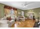 Well-lit living room featuring hardwood floors, neutral furniture, and large windows with decorative curtains at 647 E 3Rd Ave, Mount Dora, FL 32757