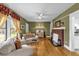 Bright living room boasts hardwood floors, a brick fireplace, and a charming display cabinet at 647 E 3Rd Ave, Mount Dora, FL 32757