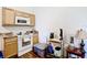 Galley kitchen features white appliances, wood-look floors and light wood cabinets at 6710 Winkles St, Coleman, FL 33521