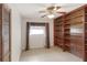 Bedroom featuring tile floors, built-in wooden shelving, a window, and a closet with louvered doors at 7378 Ne 49Th Ln, Wildwood, FL 34785