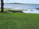 Lakeside retreat with a lush green lawn leading to the dock with beautiful water views at 7378 Ne 49Th Ln, Wildwood, FL 34785