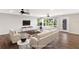 Staged living room with modern furniture, wood-look tile flooring, and bright natural light at 7378 Ne 49Th Ln, Wildwood, FL 34785
