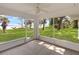Relaxing screened-in porch offering panoramic views of the lush green lawn and tranquil waterfront at 7378 Ne 49Th Ln, Wildwood, FL 34785