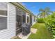 Exterior backyard view features a covered grill and screened porch with outdoor furniture, perfect for entertaining at 762 Turbeville Ter, The Villages, FL 32162