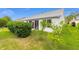 Well-maintained backyard with lush lawn, manicured hedges, and a glimpse of the home's screened porch at 762 Turbeville Ter, The Villages, FL 32162