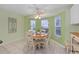Light-filled breakfast nook with a round table, ceiling fan, and a bay window at 762 Turbeville Ter, The Villages, FL 32162