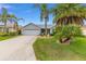 Attractive single-story home with lush landscaping, palm trees, and a well-maintained front yard at 762 Turbeville Ter, The Villages, FL 32162