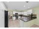 Well-lit kitchen with stainless steel appliances, white cabinets, and tile flooring at 762 Turbeville Ter, The Villages, FL 32162