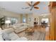 Open-concept living room showcasing hardwood floors, a ceiling fan, and a comfortable seating area at 762 Turbeville Ter, The Villages, FL 32162